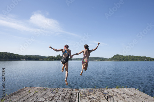 Photography Twins girls jumping off a swimming dock.