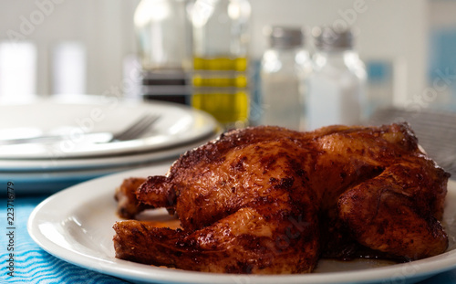 Grilled glazed chicken with table settings blurred in background