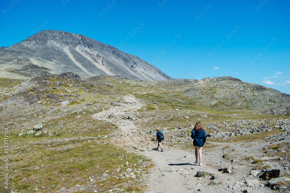 couple of hikers walking on path on Besseggen ridge in Jotunheimen National Park, Norway