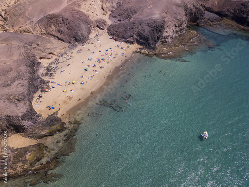 Vista aerea delle coste frastagliate e delle spiagge di Lanzarote, Spagna, Canarie. Strade e sentieri sterrati. Bagnanti in spiaggia e nell’Oceano Atlantico. Papagayo