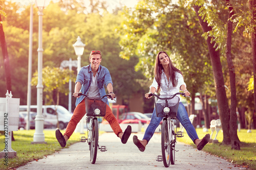 Happy autumn funny couple riding on bicycle