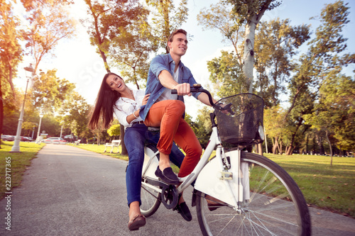 Happy funny couple riding on bicycle autumn