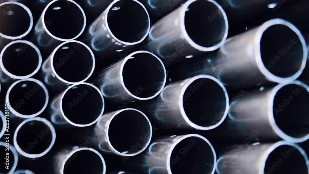 Metal profile pipe of round section in packs at the warehouse of metal products. Close-up of metal pipe. Warehouse for finished products of metal pipes of circular cross-section at the factory. Metal profile pipe of round section in packs at the warehouse of metal products. Close-up of metal pipe. Warehouse for finished products of metal pipes of circular cross-section at the factory.