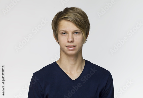 Handsome happy young man wearing blue t-shirt studio portrait against white wall