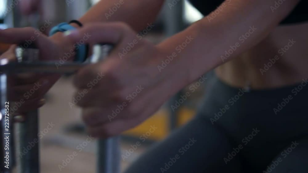 Close upof an attractive blonde girl doing exercises for abdominal muscules using a pushing trainer at gym. Slow motion Close upof an attractive blonde girl doing exercises for abdominal muscules using a pushing trainer at gym. Slow motion