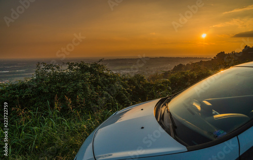 car parked in a street with a stunning view at sunset