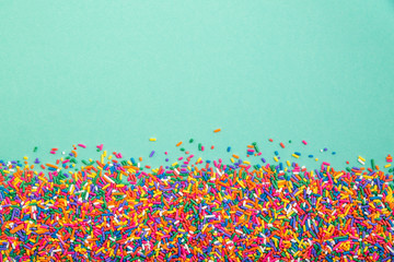 Colorful sprinkles on bottom of green background