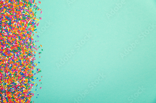Colorful sprinkles on edge of green background