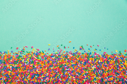 Colorful sprinkles on bottom of green background