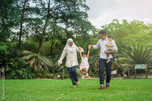 malay family having quality time in a park with morning mood