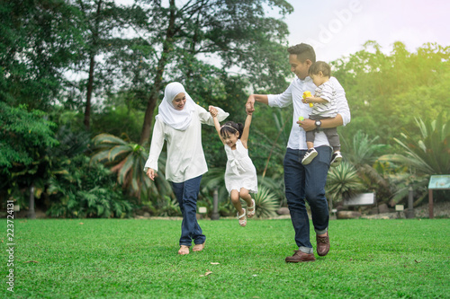 malay family having quality time in a park with morning mood photo