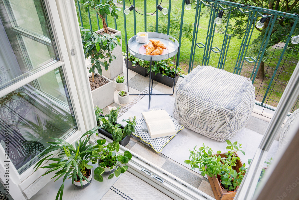 Top view of a balcony with plants, pouf a table with breakfast - obrazy, fototapety, plakaty 