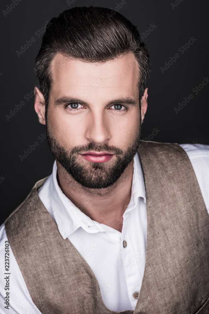 Obraz premium portrait of confident bearded man looking at camera, isolated on grey