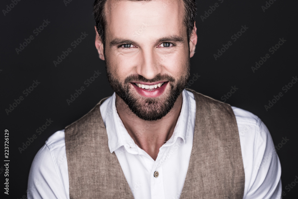 portrait of handsome smiling man looking at camera, isolated on grey portrait of handsome smiling man looking at camera, isolated on grey