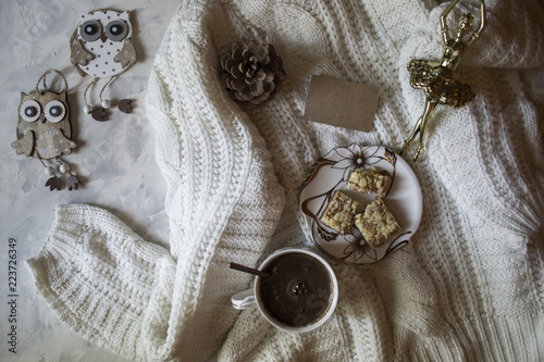 A cup of coffee, woolen sweater and Christmas decorations. Winter still life.