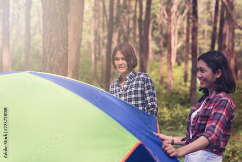 Young Asian travelers  camping and setting up tents for overnight in the forest
