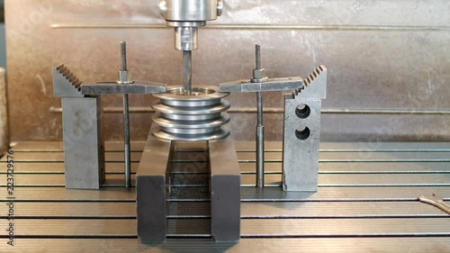 Drilling a hole with a drilling machine in a metal workpiece pulley, close-up, industry, sheave