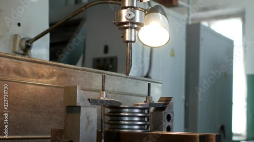 Drilling a hole with a drilling machine in a metal workpiece pulley, close-up, industry, reaming photo