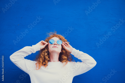 redhead girl blue sunglasses posing outdoor