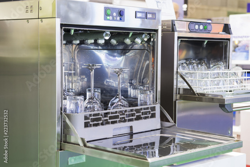 Open door of dishwasher with clean glasses by using water; food industrial equipment background photo