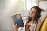 Brunette woman at home reading book