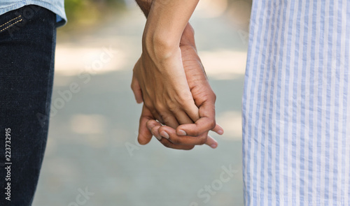 African-american couple holding hands while walking in park