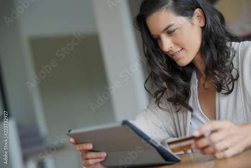 Brunette woman buying on internet, connected with tablet