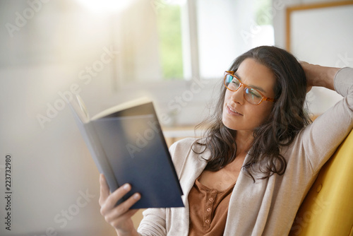 Brunette woman at home reading book photo