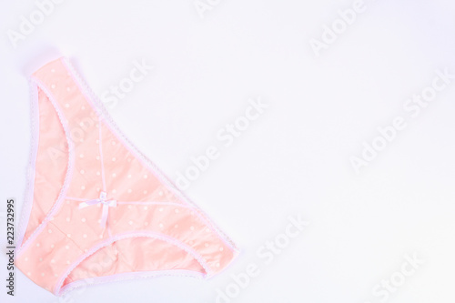 Beige women's panties on a white background. Top view, flat layout. Copy the space.