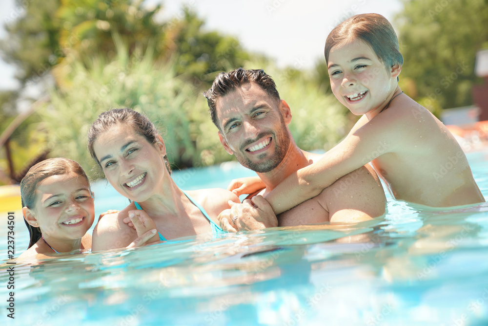 Portrait of happy family at the swimming-pool in summer Portrait of happy family at the swimming-pool in summer