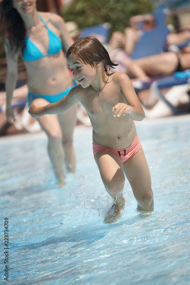 Young boy running in swimming-pool, mom behind Stock Photo | Adobe Stock
