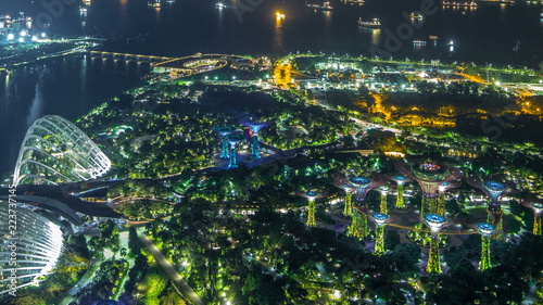 Fototapeta Naklejka Na Ścianę i Meble -  An aerial view of Gardens by the Bay and industrial ships in Singapore port timelapse.