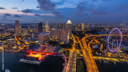 Skyline of Singapore with famous Singapore Ferries Wheel day to night timelapse at twilight