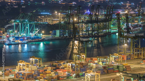 Commercial port of Singapore night timelapse. Bird eye panoramic view of busiest Asian cargo port