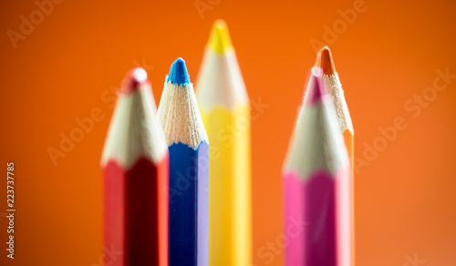 Set of multicoloured pencil or crayon on orange background.Selective focus