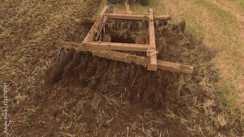 Slow motion view of tractor plowing a field a from drone