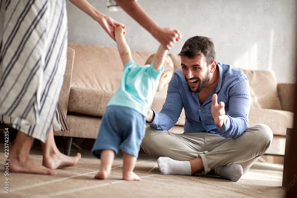 Fototapeta premium happy family mother and father playing with a baby at home.