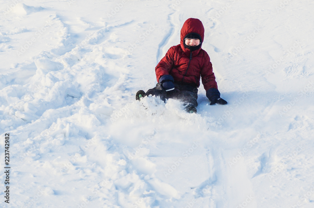 Boy riding down the slope of a snowy hill