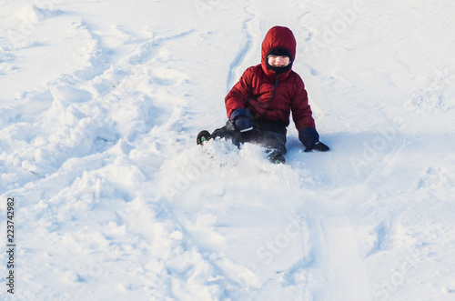 Boy riding down the slope of a snowy hill