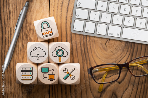 Symbole für Cloud Services auf Würfeln am Arbeitsplatz