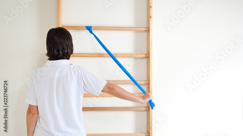 Woman doing exercise with blue elastic ribbon