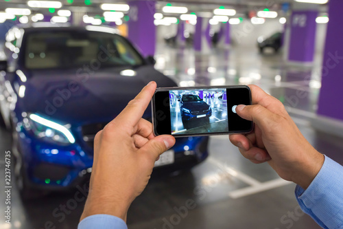 Phone in the man's hands against the background of the car.