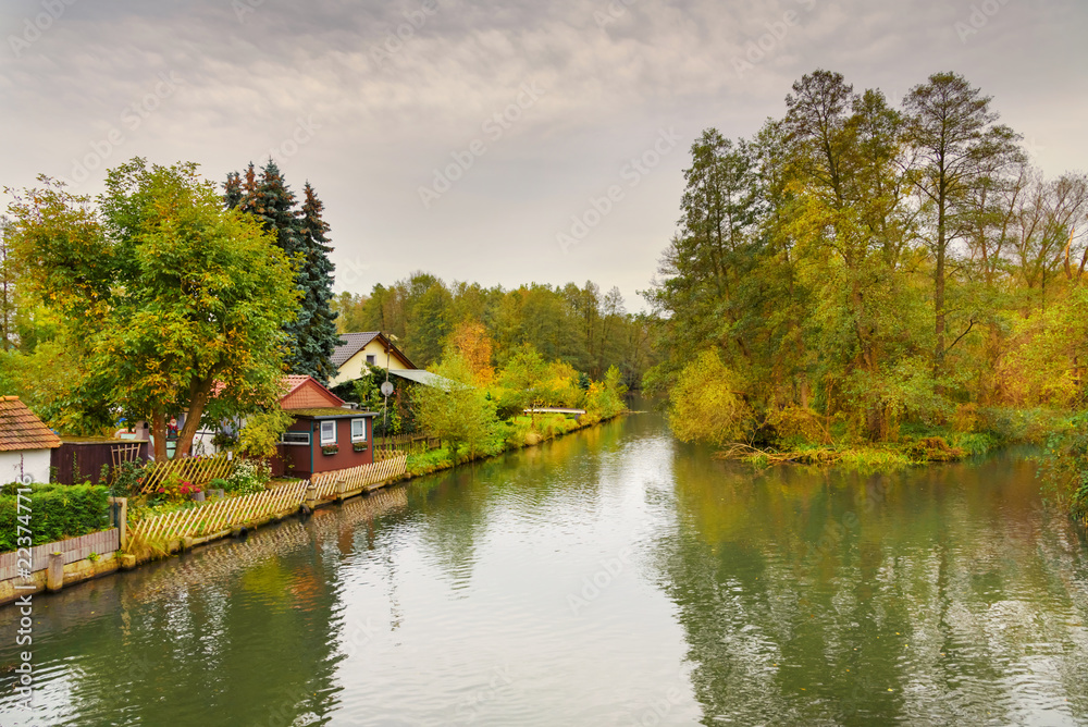 The charm of the park-like autumn colorful landscape of small house , forests, the river Spree of the Spreewald in Germany