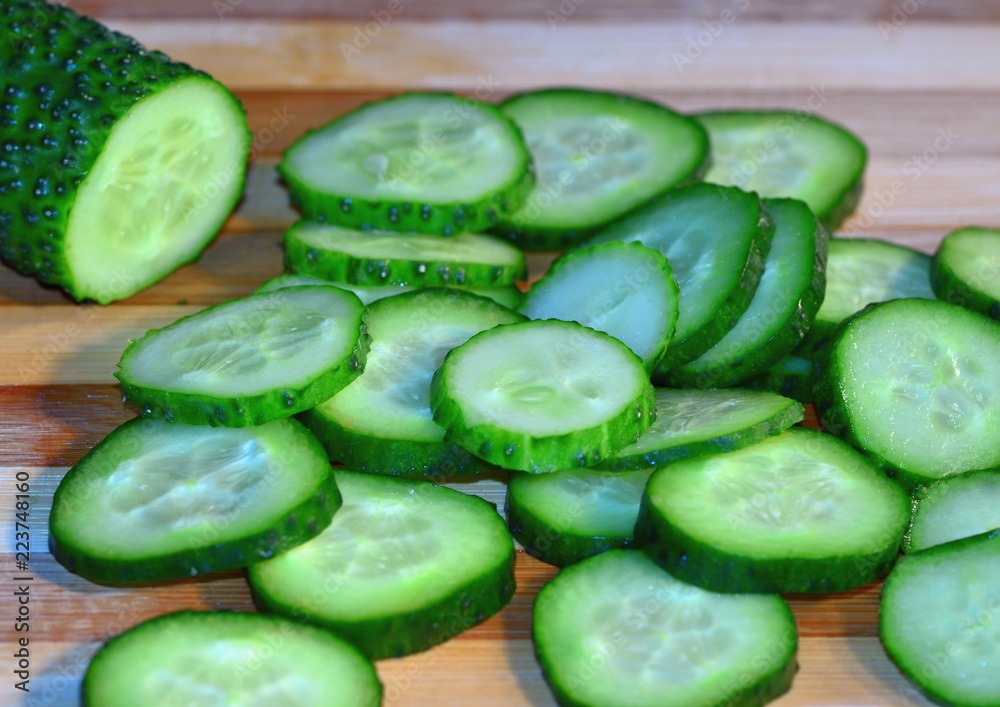 Cucumber sliced with circles lies on a wooden board, cooking, healthy food and vitamins Cucumber sliced with circles lies on a wooden board, cooking, healthy food and vitamins