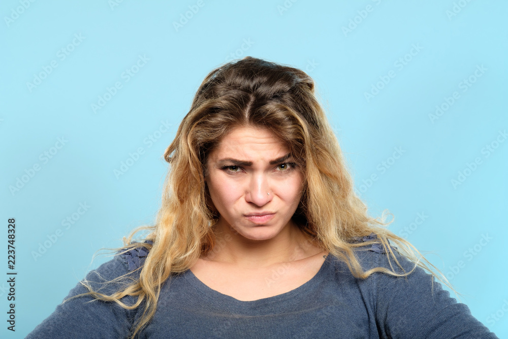 distrustful skeptic look. dissatisfied discontented displeased disgruntled woman portrait on blue background. emotional facial expressions and reaction concept. distrustful skeptic look. dissatisfied discontented displeased disgruntled woman portrait on blue background. emotional facial expressions and reaction concept.