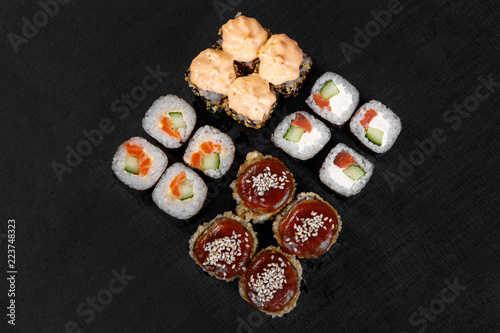 Set of sushi, rolls, uramaki, hosomaki, tempura, with teriyaki, lava sauce, raw seafood, soy sauce, marinated ginger and wasabi, black isolated background view from above For the menu, restaurant