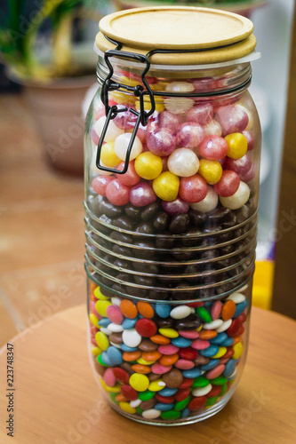 A large container with colorful candies with a tight-fitting lid. Sweets