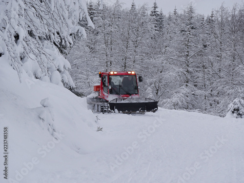 Snowcat makes ski trails in snow-covered mountains