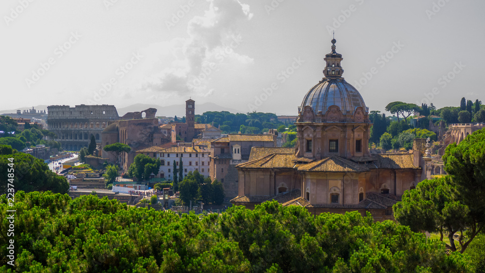 Beautiful historical landmarks and architecture of Rome: Colosseum, Basilica, ancient ruins of the Forum Caesar, Temple of Peace with a sky and hills