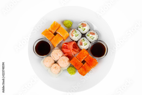 Set of sushi, rolls, uramaki, hosomaki, california, philadelphia, lava sauce, raw seafood, soy sauce, marinated ginger and wasabi on plate, white isolated background view from above For the menu